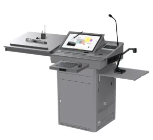 The Multimedia Digital Podium with Touchscreen and Document Camera is an advanced all-in-one presentation solution designed for universities, colleges, smart classrooms, training centers, conference rooms and seminar halls. It combines digital teaching, audio control, document presentation and multimedia management within one professional podium system. The podium features an integrated angled touchscreen monitor that allows presenters to control slides, documents, videos and interactive learning content directly from the lectern. A built-in or mounted document camera enables teachers and speakers to display printed documents, books, diagrams, samples and physical objects on a connected projector, LED display or interactive flat panel. Its gooseneck microphone supports clear voice delivery during lectures and presentations. The extended side platforms provide convenient space for a laptop, documents, wireless microphone, control devices and other presentation accessories. A pull-out keyboard and mouse tray helps users operate the integrated computer comfortably. The durable metal cabinet offers protected internal storage for a computer, amplifier, switching equipment and multimedia accessories. Its organized design helps reduce visible cables and keeps the presentation area clean. This multifunction digital podium is ideal for institutions that require a centralized teaching and presentation platform with touchscreen control, document visualization, microphone support and external display connectivity.