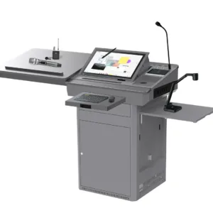 The Multimedia Digital Podium with Touchscreen and Document Camera is an advanced all-in-one presentation solution designed for universities, colleges, smart classrooms, training centers, conference rooms and seminar halls. It combines digital teaching, audio control, document presentation and multimedia management within one professional podium system. The podium features an integrated angled touchscreen monitor that allows presenters to control slides, documents, videos and interactive learning content directly from the lectern. A built-in or mounted document camera enables teachers and speakers to display printed documents, books, diagrams, samples and physical objects on a connected projector, LED display or interactive flat panel. Its gooseneck microphone supports clear voice delivery during lectures and presentations. The extended side platforms provide convenient space for a laptop, documents, wireless microphone, control devices and other presentation accessories. A pull-out keyboard and mouse tray helps users operate the integrated computer comfortably. The durable metal cabinet offers protected internal storage for a computer, amplifier, switching equipment and multimedia accessories. Its organized design helps reduce visible cables and keeps the presentation area clean. This multifunction digital podium is ideal for institutions that require a centralized teaching and presentation platform with touchscreen control, document visualization, microphone support and external display connectivity.